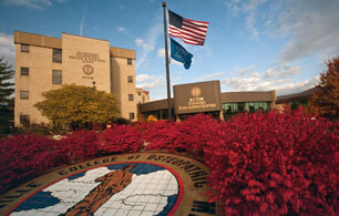 Image of KCOM campus and entrance and flags