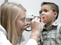 Image of ATSU dental student inspecting mouth of child patient