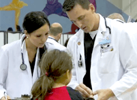 Image of two ATSU medical students treating a young patient.