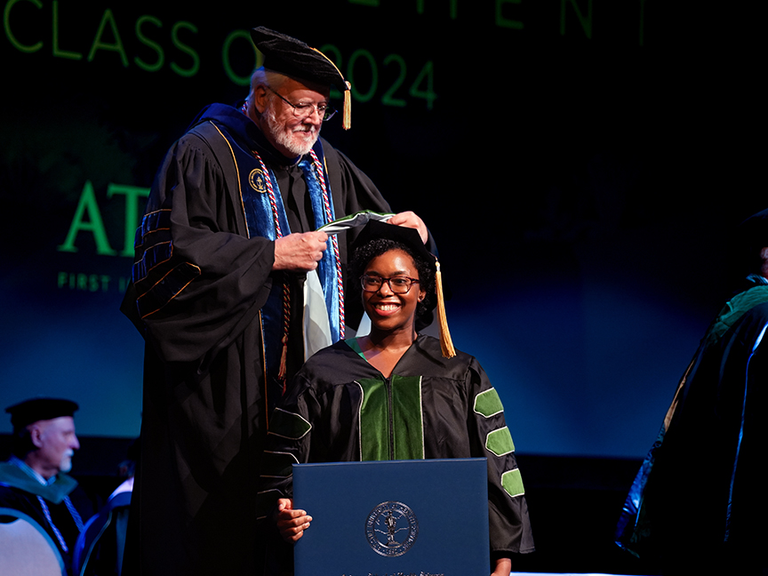 ATSU DMSc graduate receiving an academic hood on stage during the commencement ceremony