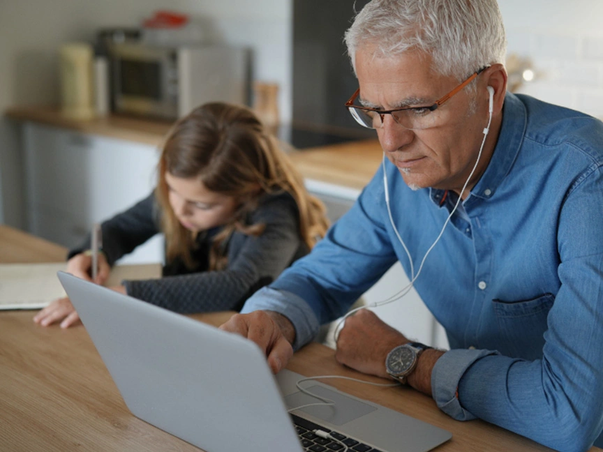 Father and daughter studying together, with the father working on his ATSU Audiology degree assignments