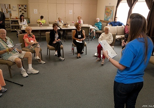 Female ATSU audiology student giving a presentation to a group of elderly people.