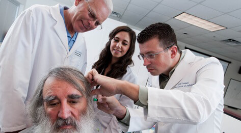 Image of ATSU audiology professor demonstrating proper patient ear exam to ATSU audiology students