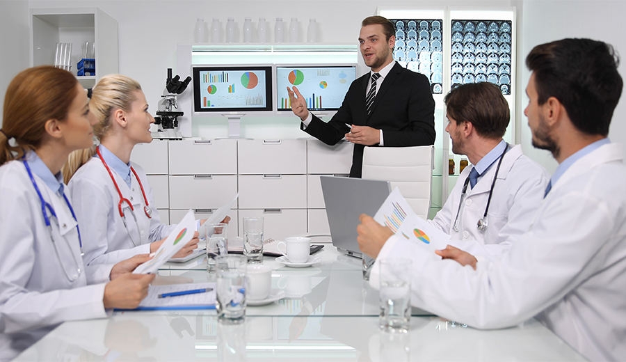 Business man showing graphs to doctors