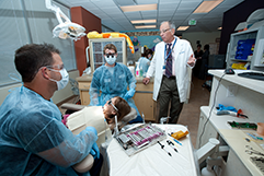 Dental students and dentist working on patient.