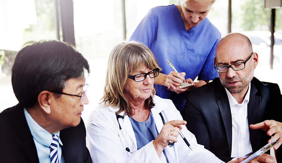 Doctor, nurse, business men looking at paper work