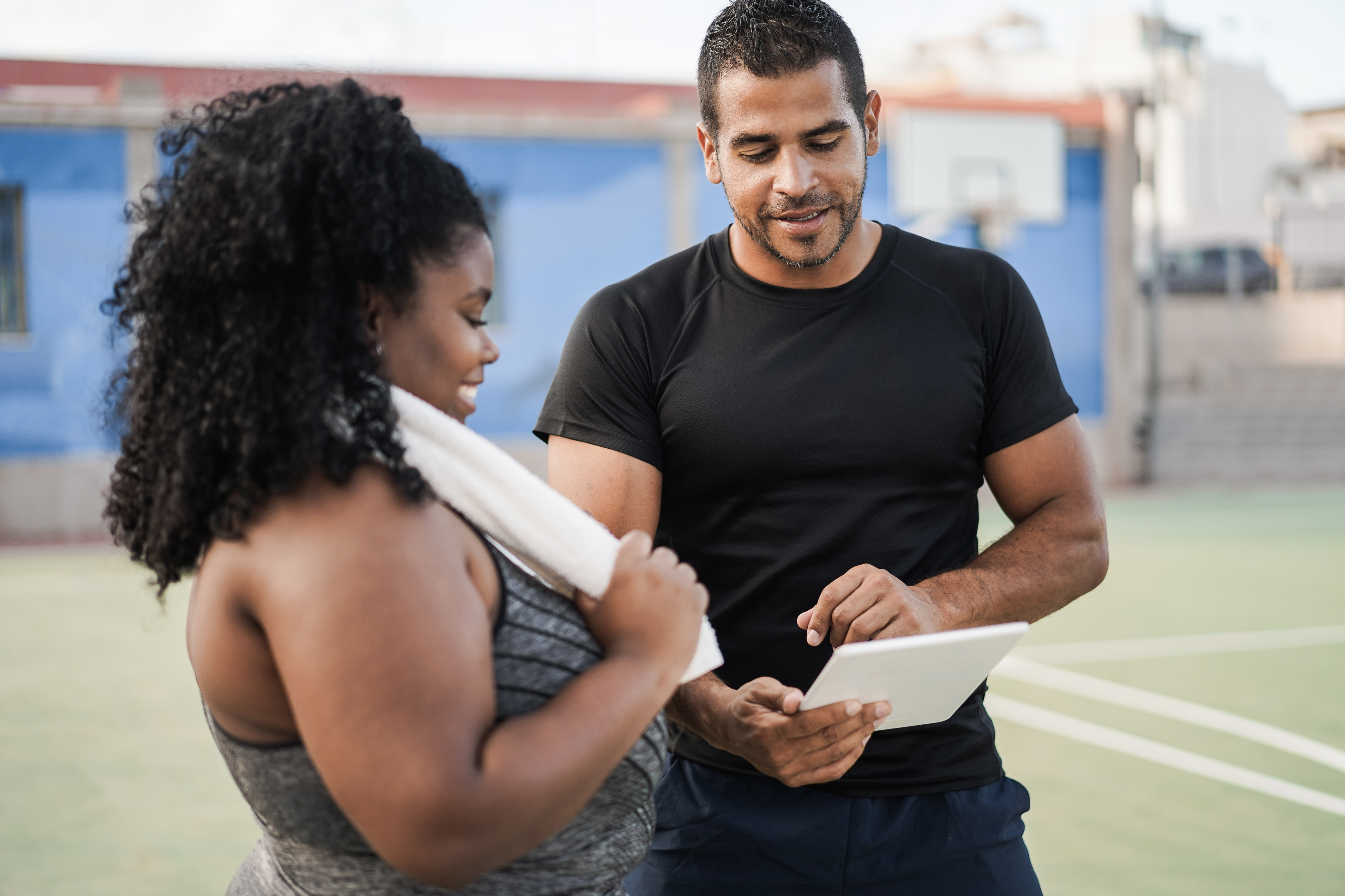 Masters in Kinesiology athletic trainer and trainee reviewing a paper, emphasizing hands-on learning and mentorship in the program.