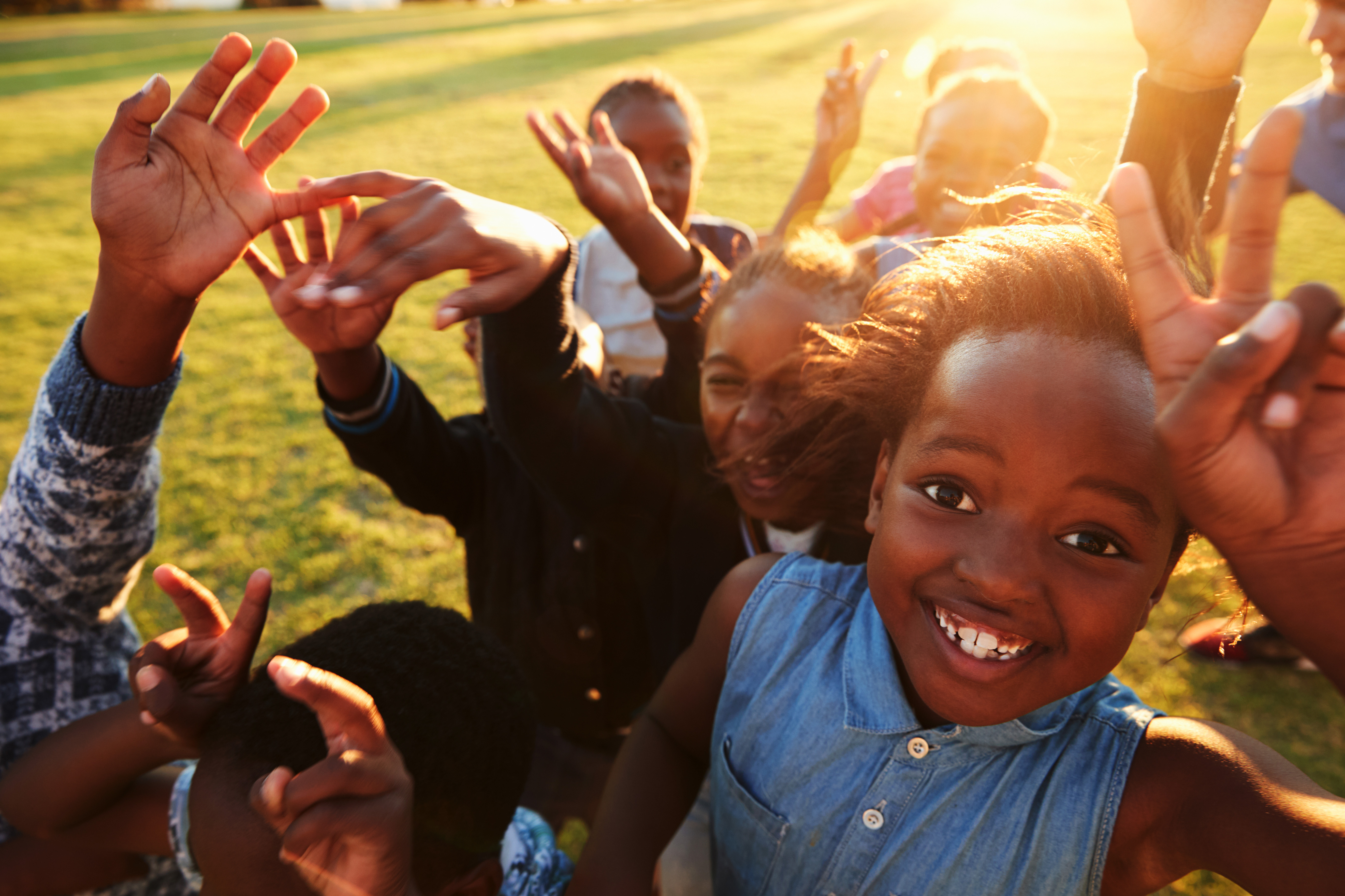 Children playing together in a grassy field, representing community wellness and outdoor activity emphasized in the Master of Public Health program.