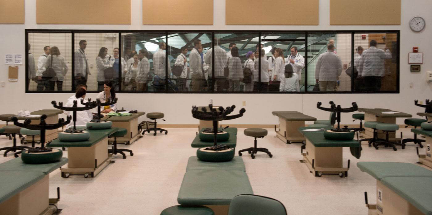 Medical students gathered together, all wearing white lab coats.