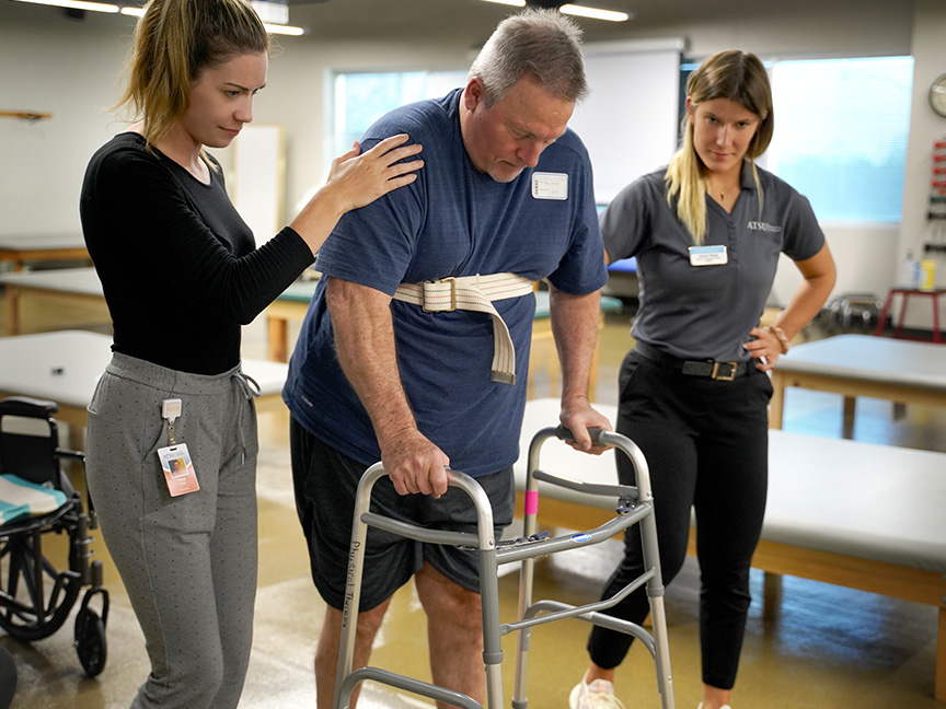 OT helping a patient walk