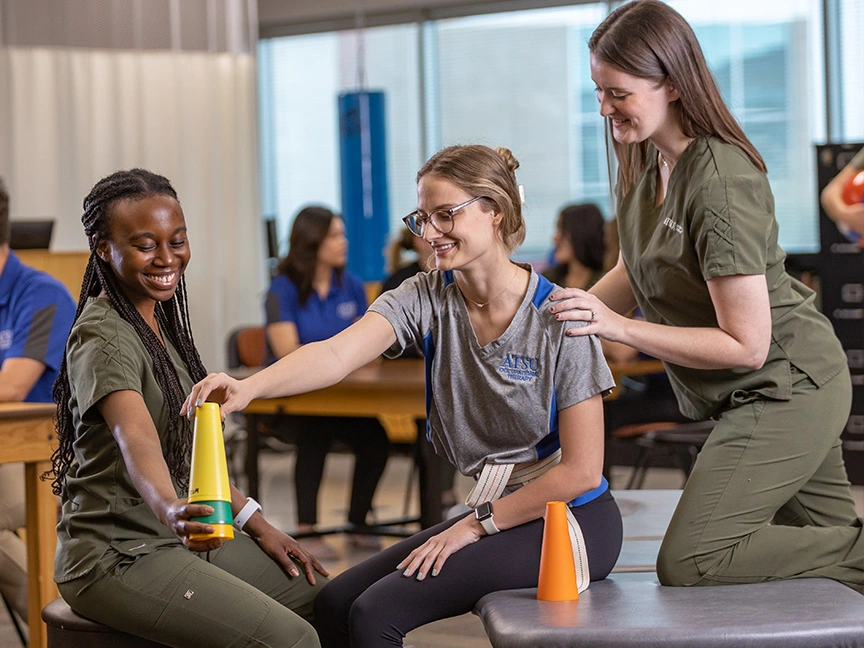 OTD Students helping patient stack cups