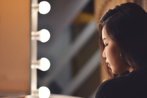 Lady staring down in front of mirror