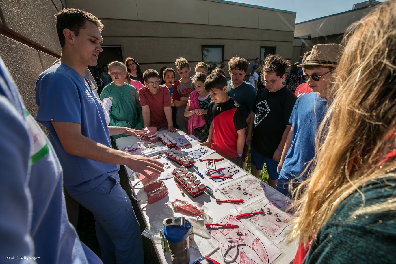 Young students learning about dental healthcare from ATSU-MOSDOH student