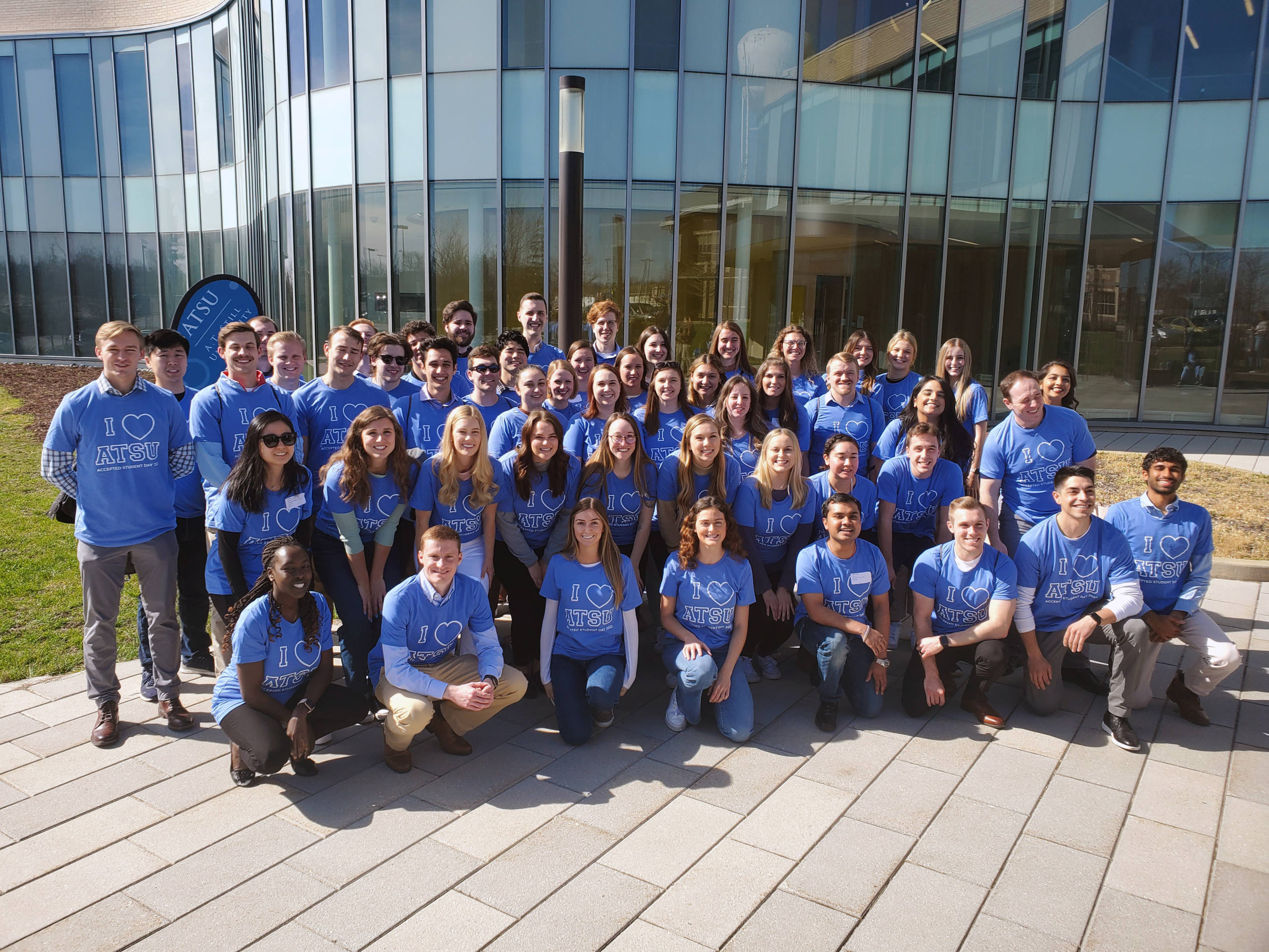 Future students pose in front of a building.