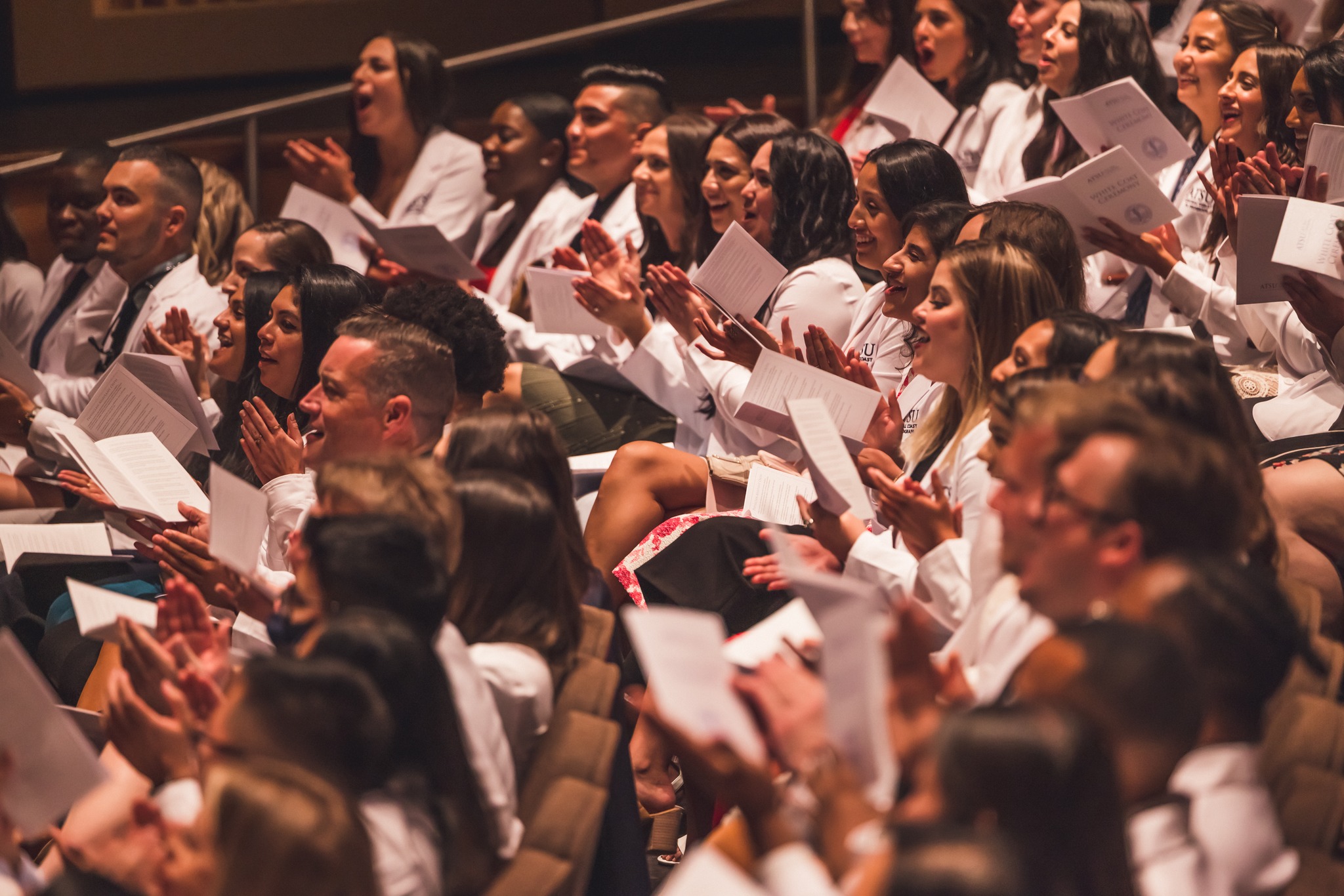 A.T. Still University-College for Healthy Communities (ATSU-CHC) Central Coast Physician Assistant (CCPA) program students applaud in audience.