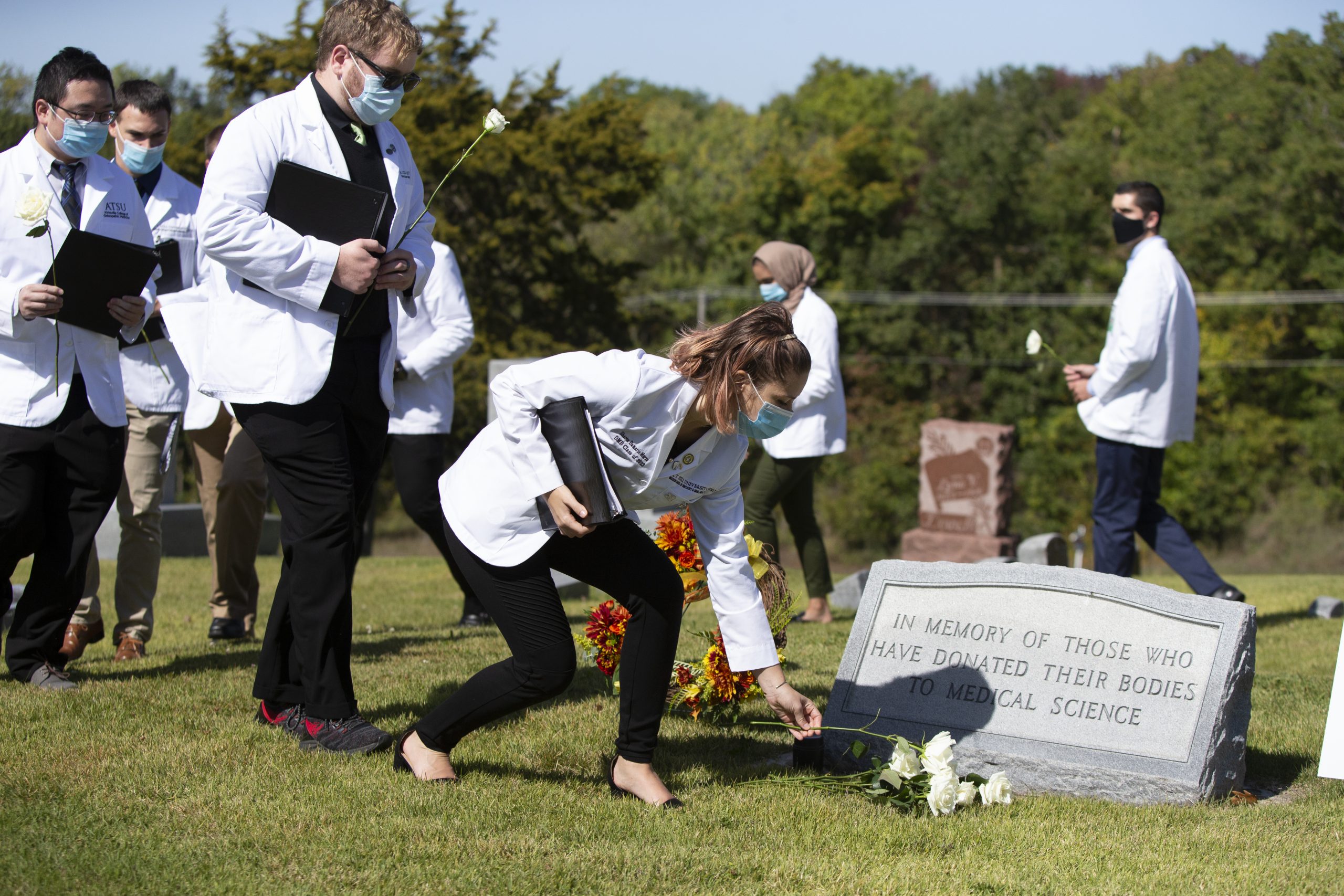 A student places a flower in memory of those who have donated their bodies to science