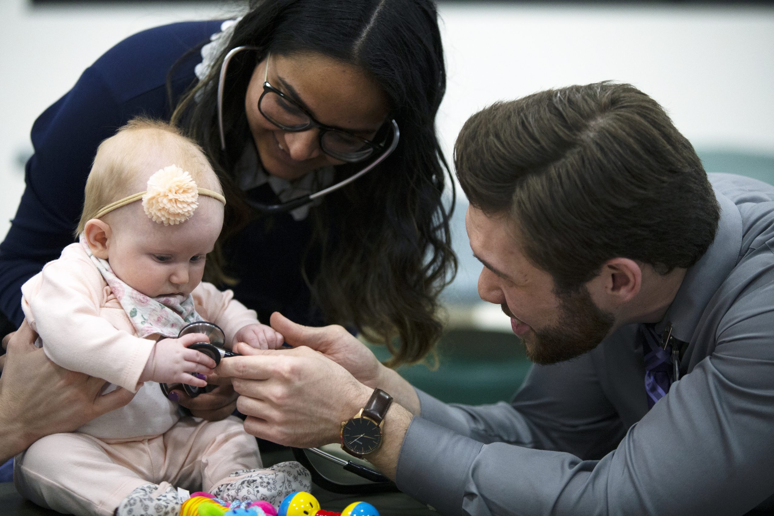 ATSU-KCOM students work with an infant during a pediatrics lab