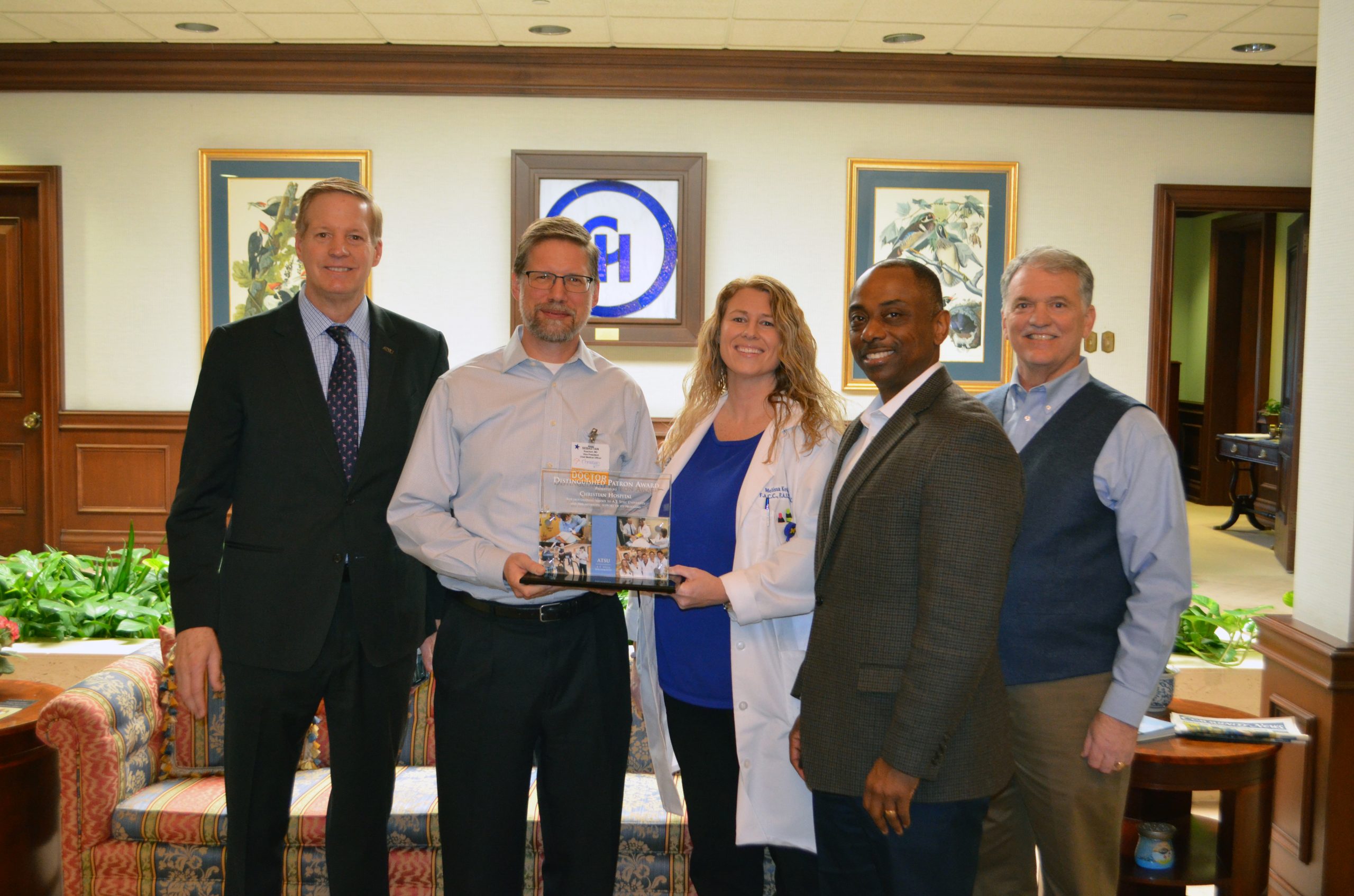 5 people standing holding award