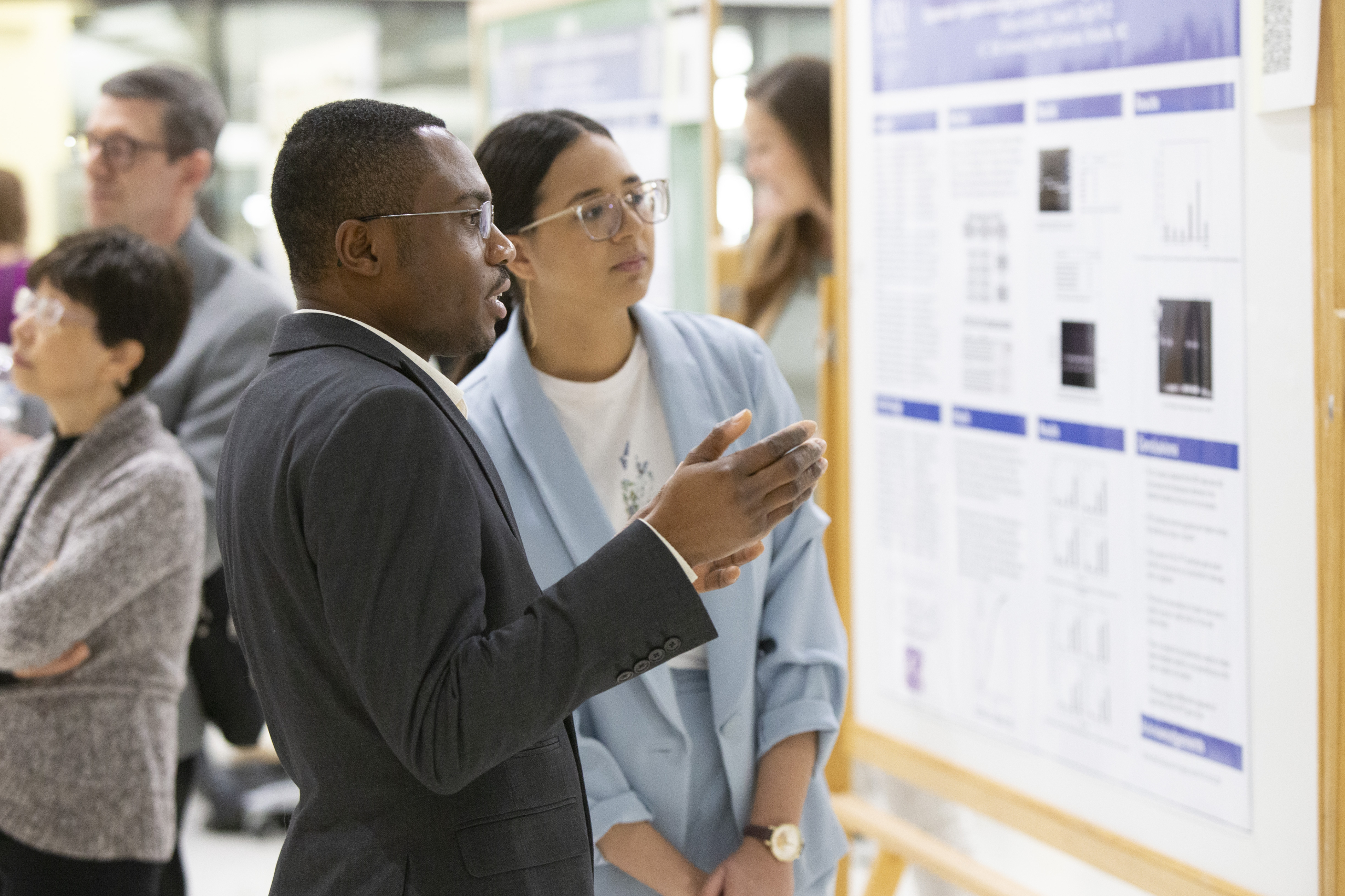 Two individuals examine a research poster during the 14th annual IBRS.