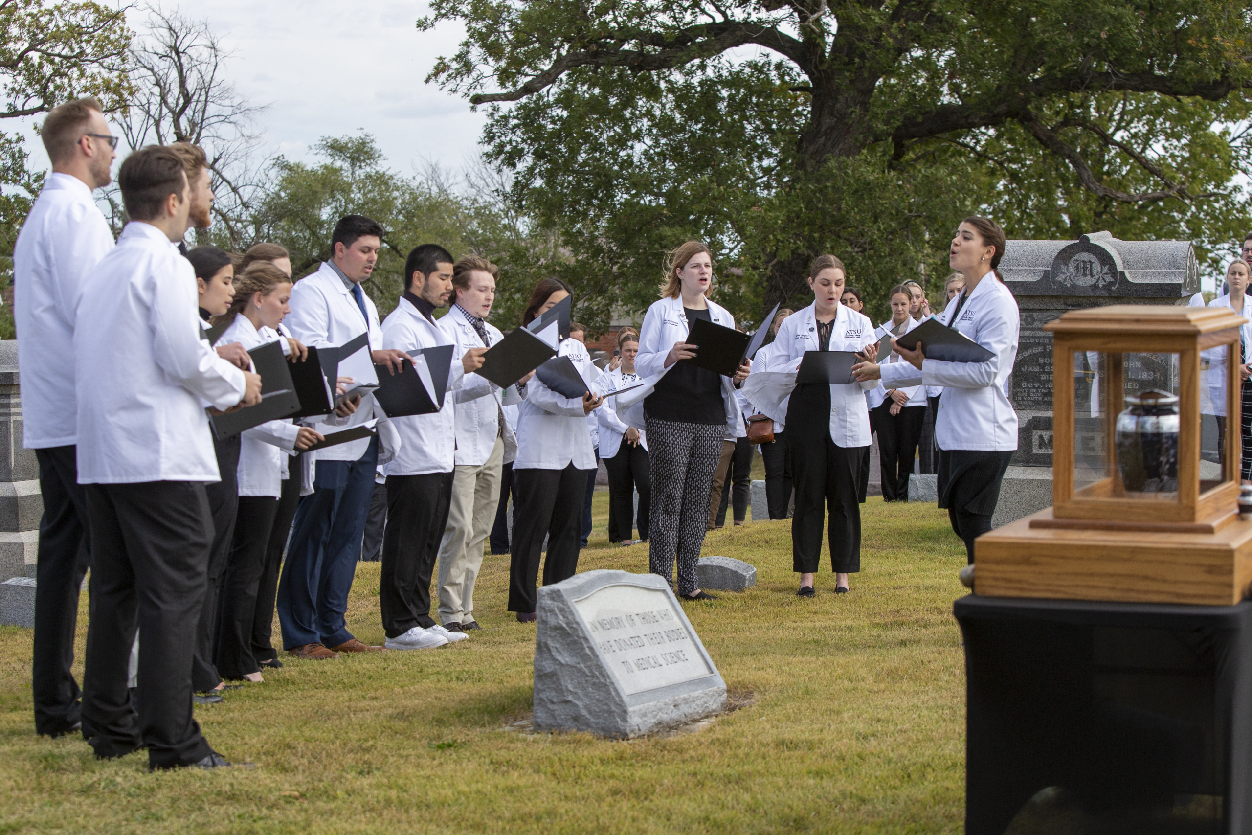 Medical students wearing white coats gather in a cemetery and sing "Amazing Grace" in honor of those who have donated their bodies to medical science.