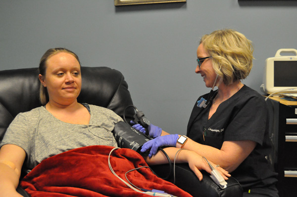 Female doctor taking blood pressure of female patient