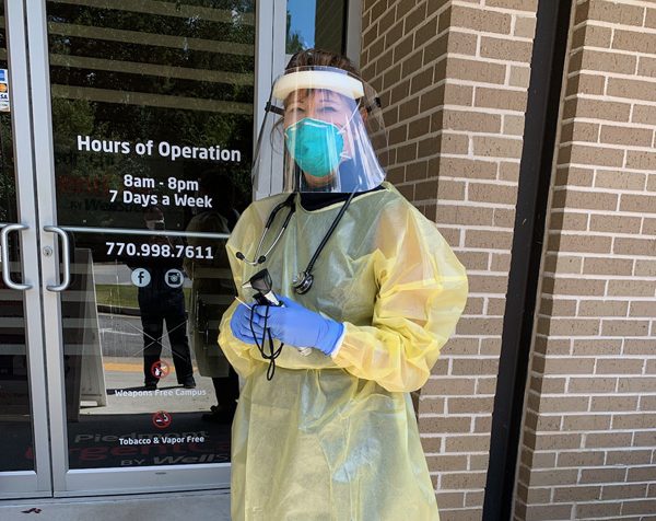Dr. Linnette Sells in PPE standing outside her clinic