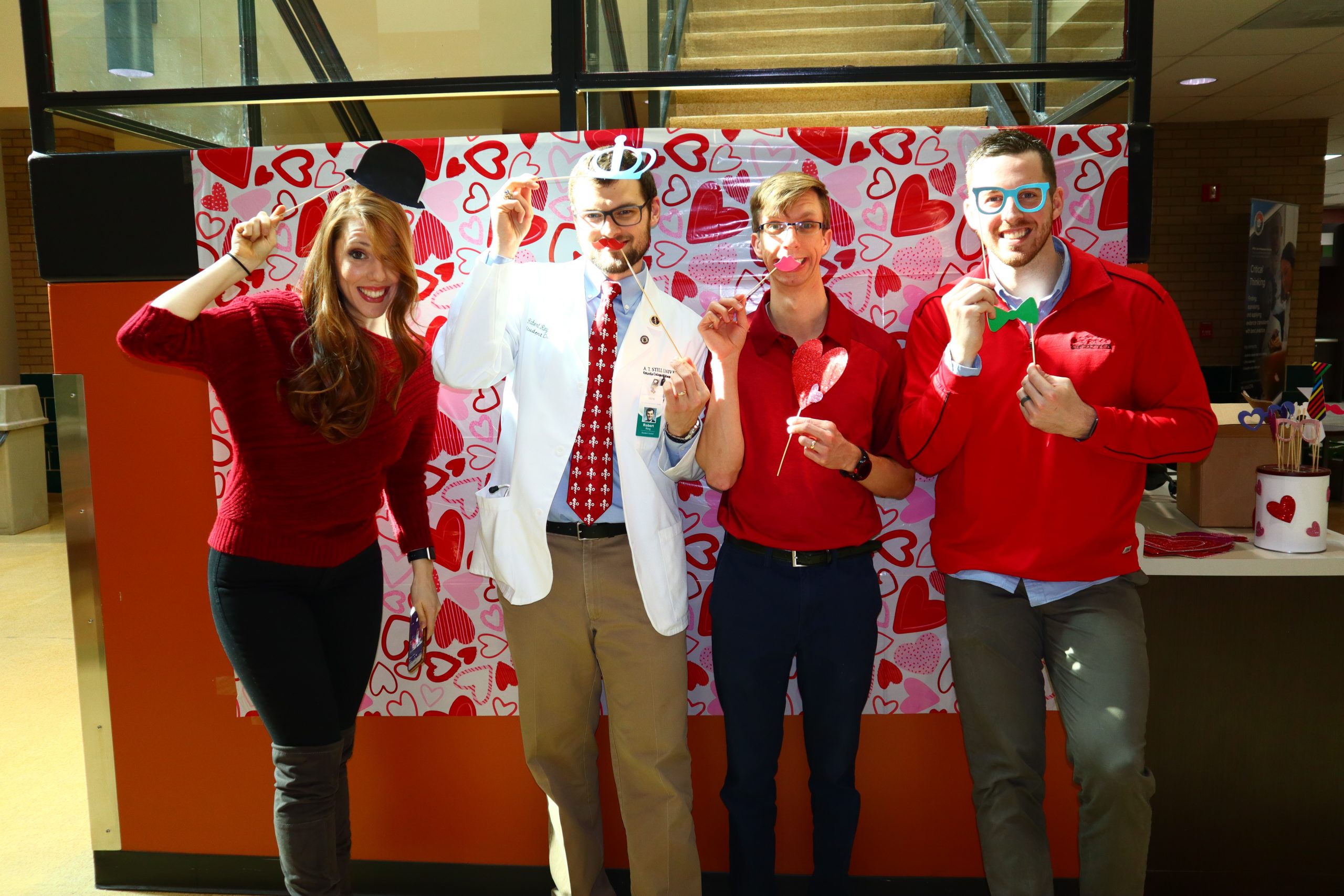 Students dressed in red in with photo booth props