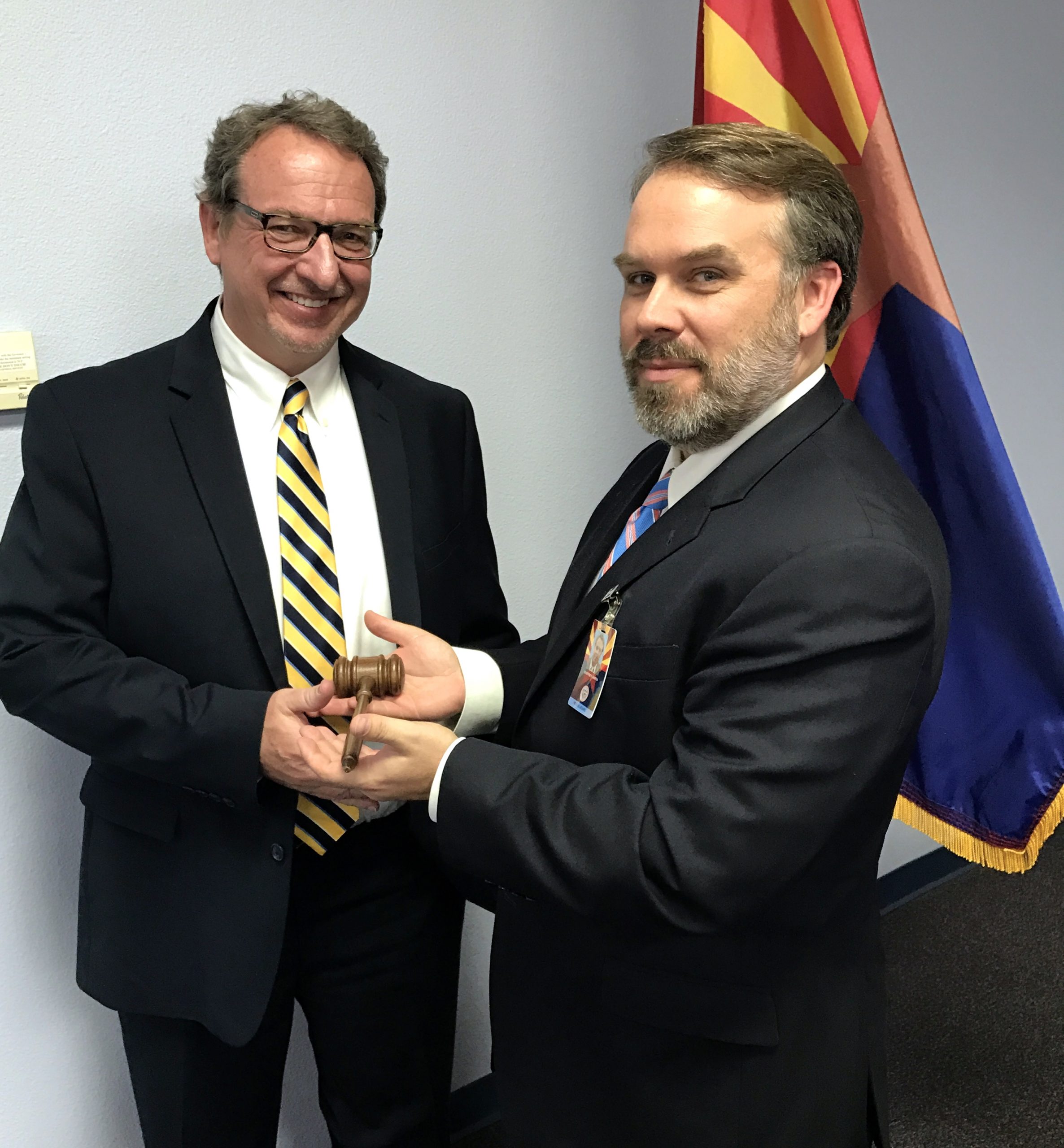 Myles Whitfield, new chair of the Arizona Regulatory Board of Physician Assistants, receives the gavel for the board from outgoing chair, Dr. Geoffrey Hoffa