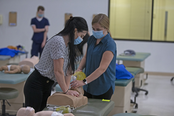 students performing CPR on manikin