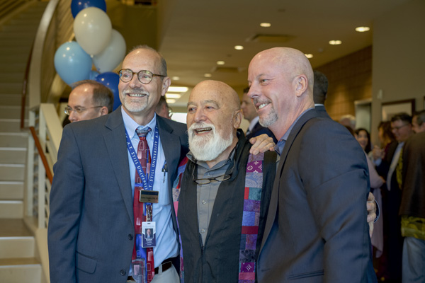 Dr. Trombly, Dr. Dillenberg, and Thorne in standing together for photo among guests