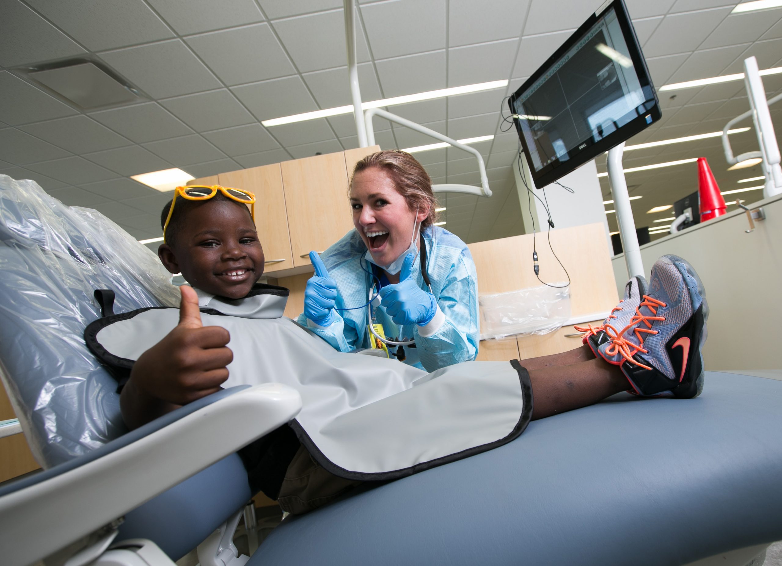 dental student and child patient giving thumbs up