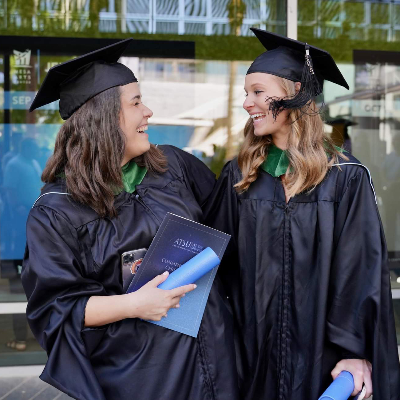 Two students smile at each other following graduation