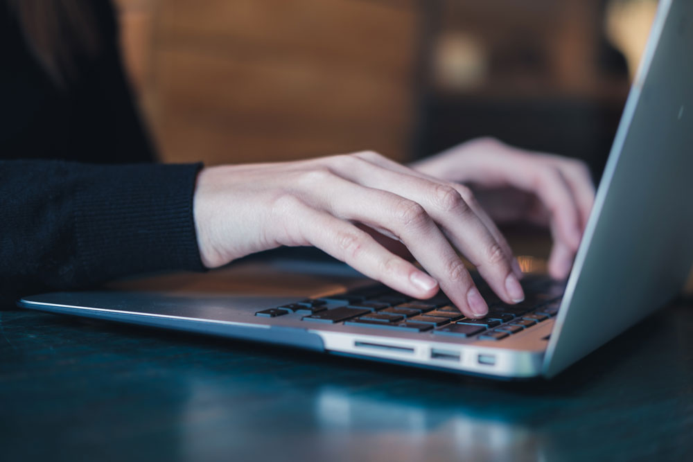 Hands sitting on a laptop